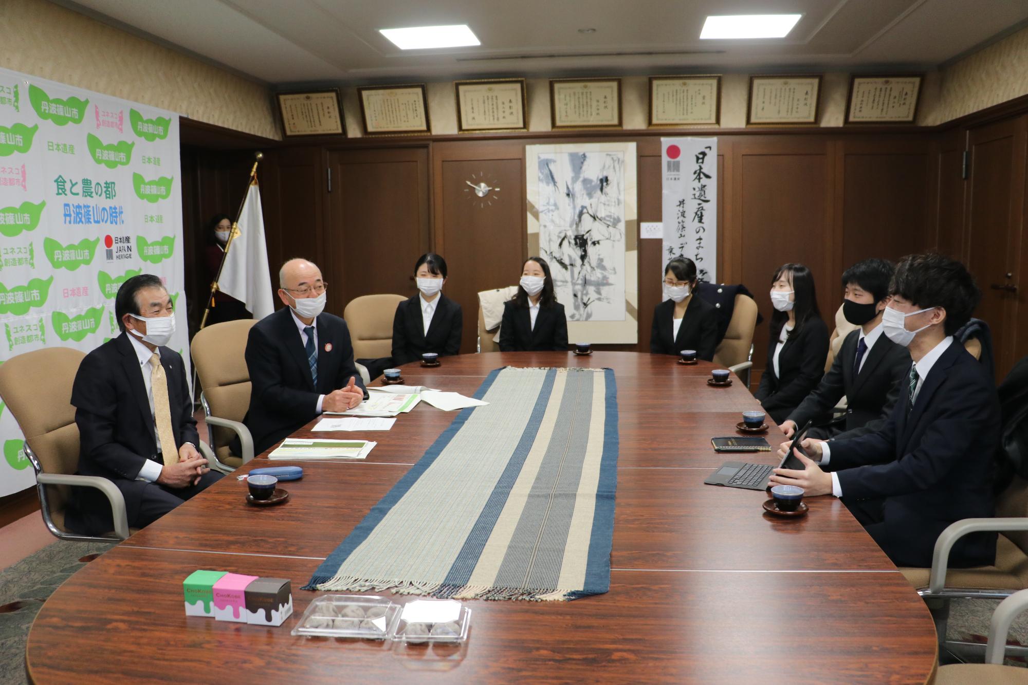 応接室で市長に受賞報告をする神戸大学の学生たち