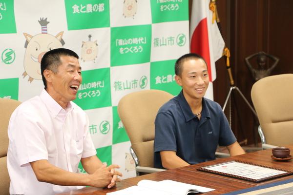 市長室にて、左に顧問の森本先生、右に清水君が笑顔で写っている写真