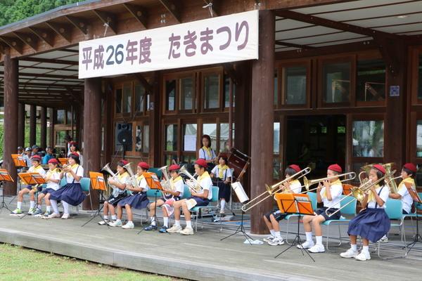 赤いベレー帽を被った吹奏楽の子ども達が演奏している写真