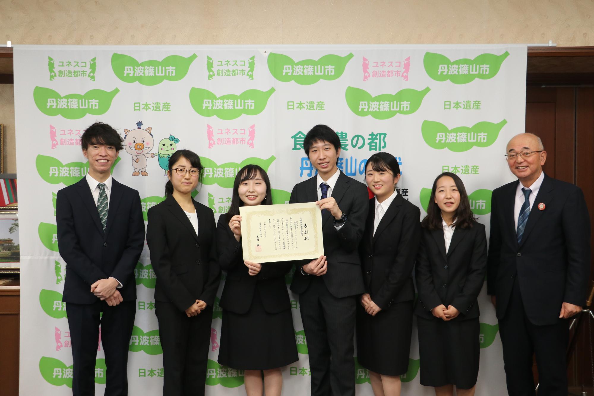 表彰状を手に市長と記念撮影する神戸大学の学生たち