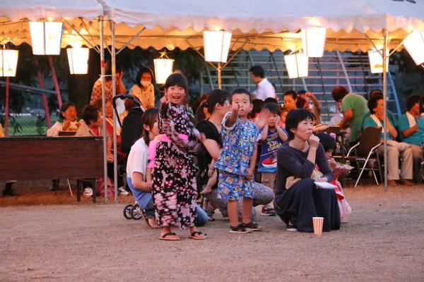 浴衣を着た女の子と甚平を着た男の子が指を指している写真