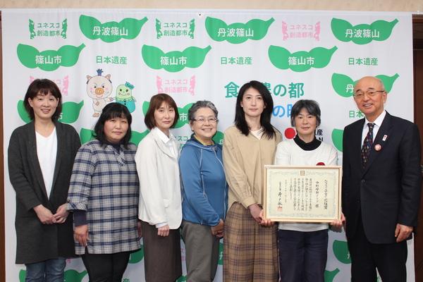 中野母親クラブ6名が賞状の入った額を手に持ち市長と一緒に記念撮影している写真