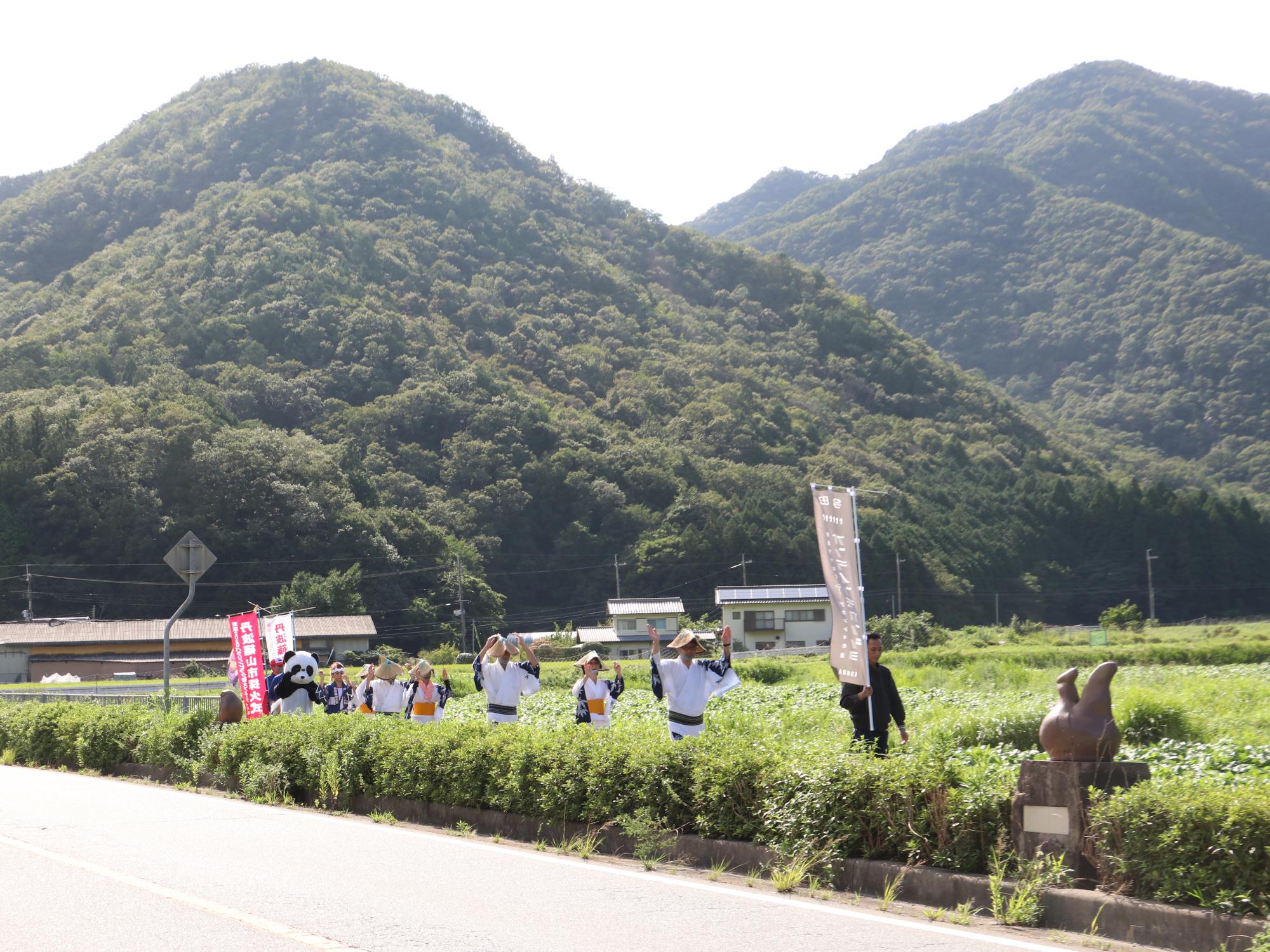 国道をデカンショを踊りながら歩いている。パンダの着ぐるみも参加している。