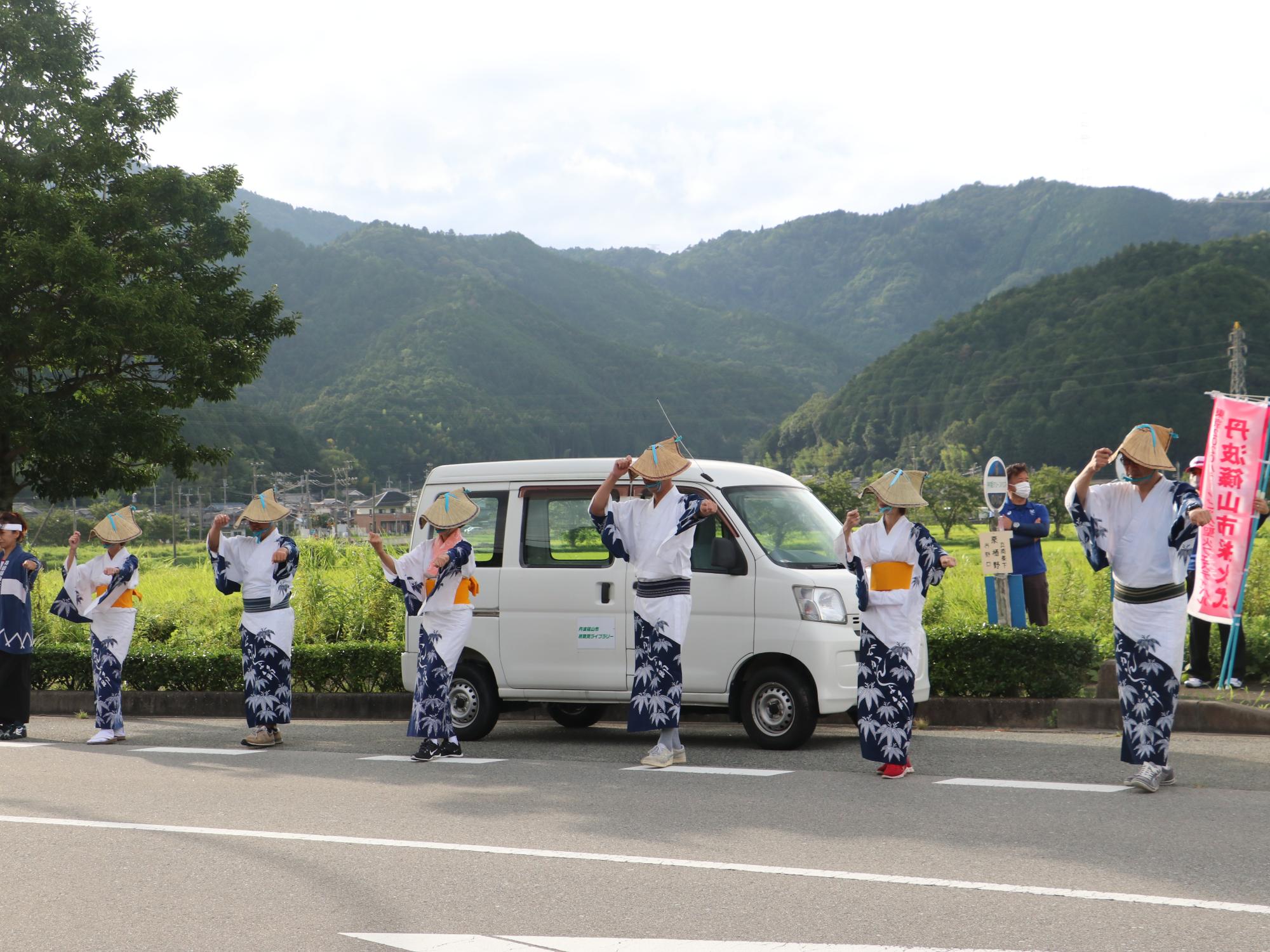 歩道で止まり、編み笠をかぶりデカンショ浴衣を着た6名が踊っている。