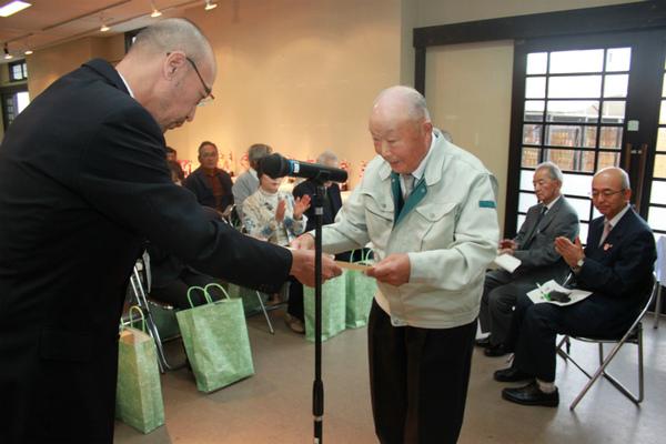 出席者の前で、兵庫県知事賞を獲った稲山 寅夫さんが市長より表彰を受けている様子の写真