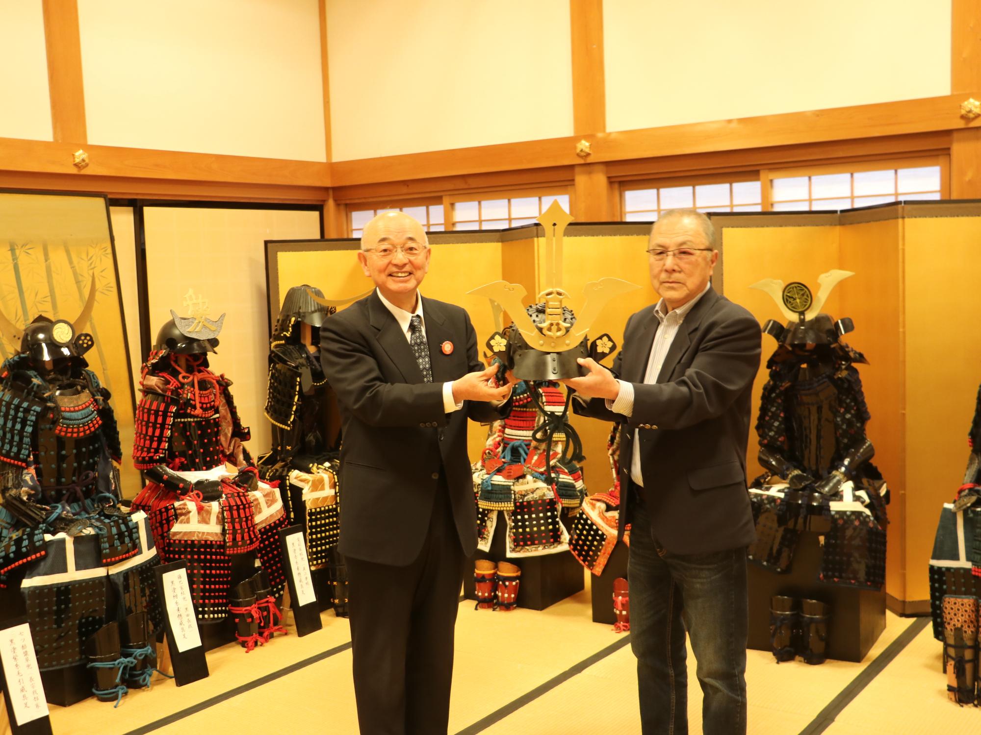 折鶴をテーブルに置き、記念撮影する市長と田中さん、上ノ谷さん