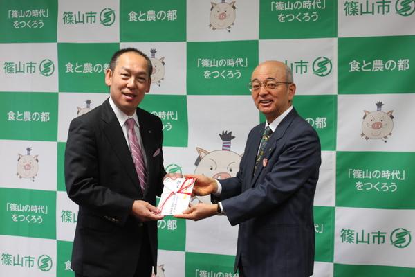 篠山市のフルヤ工業株式会社の社長、降矢 寿民さんが、市長に封筒を渡ししている写真