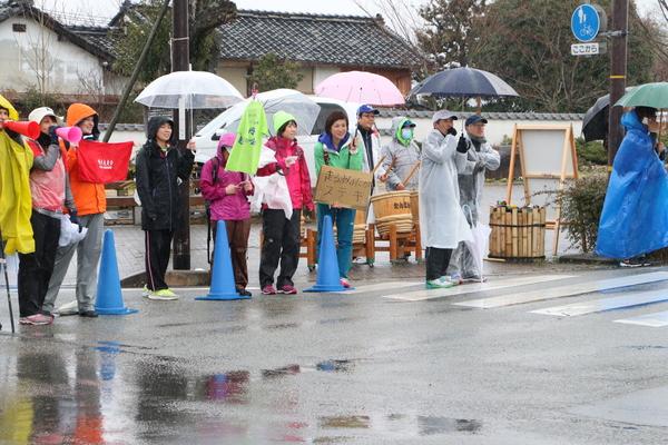 メガホンで応援している方やカッパを着て太鼓を叩いて応援している写真