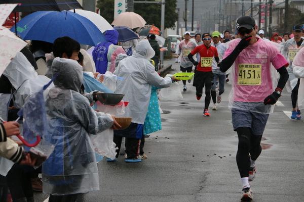 カッパ姿の方が差し入れしていて、それを選手が食べている写真