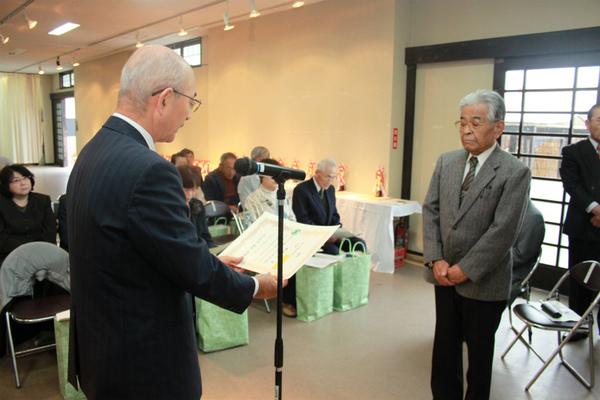 篠山市長賞を獲った酒井 優さんが出席者の前で、市長より表彰を受けている様子の写真