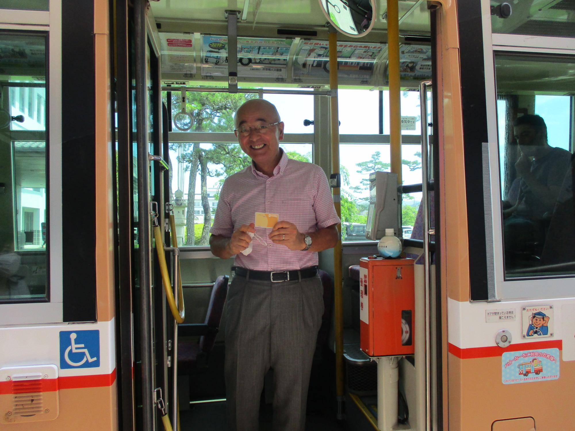 ニコパカードを手に持ってバスに乗車される市長