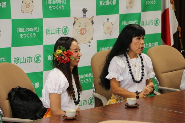 黒い玉の連なったネックレスをしたココ ポスマンさんと右耳にハイビスカスの花をつけて笑顔でお話されている畠 裕子さんの写真