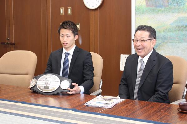 座っている、内藤正啓さんとチャンピオンベルトを持つ内藤大樹さんの写真