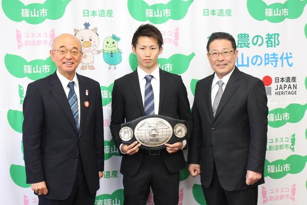 市長、チャンピオンベルトを持つ内藤大樹さん、内藤正啓さんが並んでいる写真