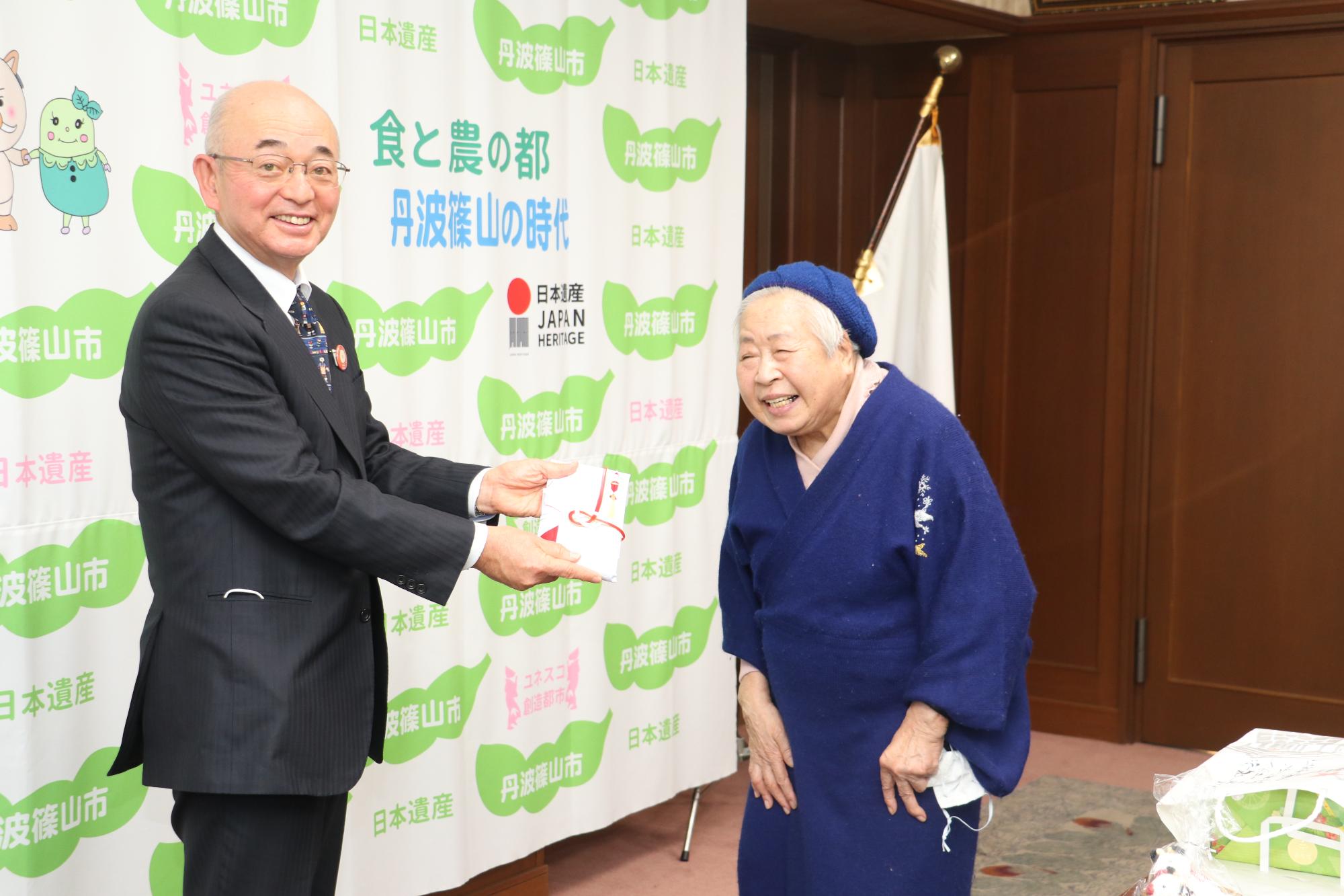 藤木さんから寄付目録を受け取った市長