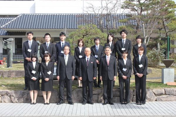 スーツ姿の男女と、市長の集合写真