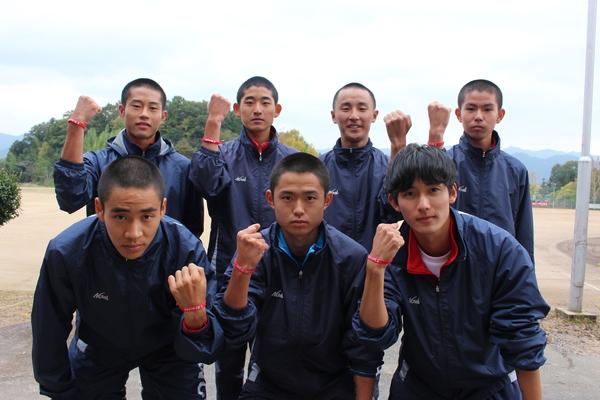 篠山鳳鳴高校男子陸上部の選手たちがお揃いのリストバンドをしてガッツポーズをしている写真