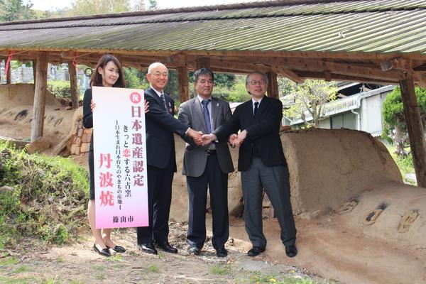土で出来た窯元の前で市長ら4名で記念撮影している写真
