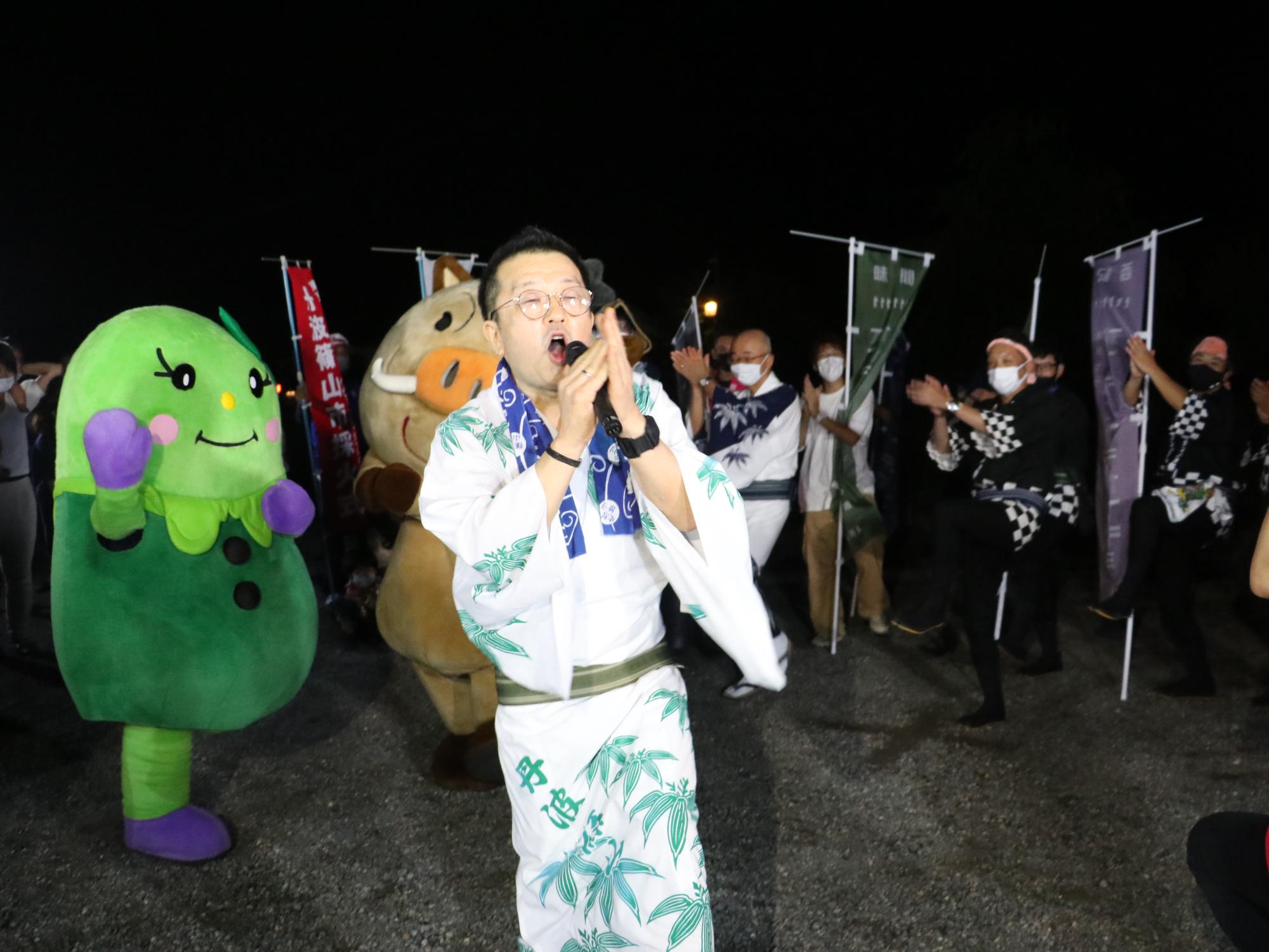 デカンショ締めをしている商工会会長。後ろにはまるいのまめりんや市長、ハッピを着た男性もデカンショ締めをしている。