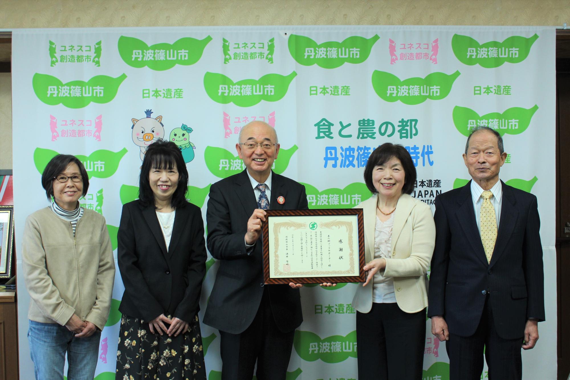 市長とブックサポータの方が一緒に感謝状を持って記念撮影されている