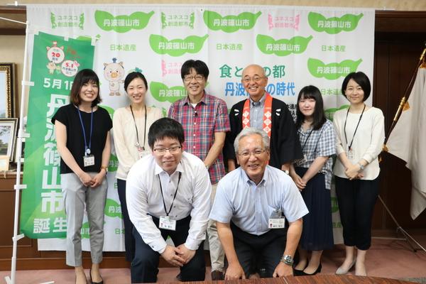 市長と女性4名と男性1名が2列目、1列目に男性2名が中腰で、皆さん笑顔の写真