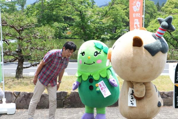 まめりんとまるいのに向かって、原田さんが上半身を傾けている写真