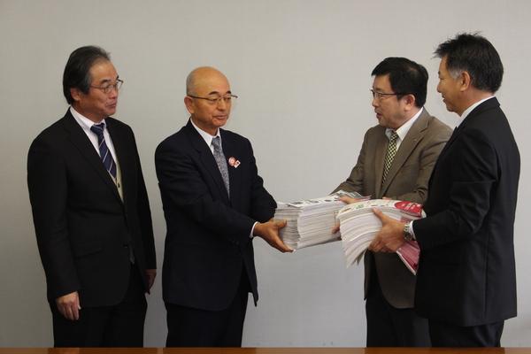 署名書類を市長へ渡している2人の男性の写真