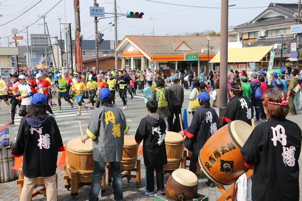 沿道で円樽と書かれた法被を着た人達が太鼓を叩いてランナー達を応援している写真