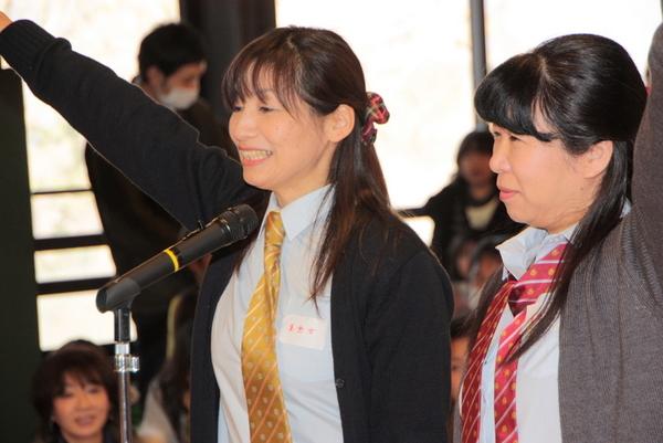 黄色と赤色のネクタイをした2名の女性が宣誓をしている写真