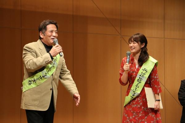 丹波篠山市のふるさと大使のタスキを肩にかけて右手にマイクを持ちステージ上でトークを行っている南条好輝さんと熊谷奈美さんの写真