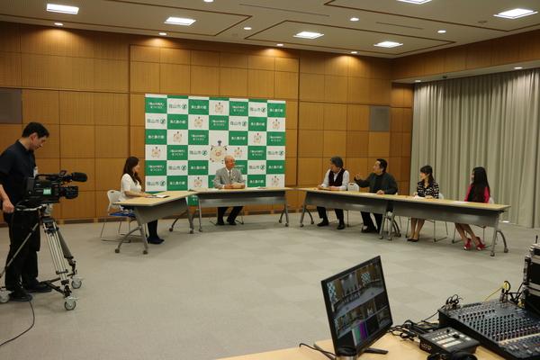 市長を中央に左側に女性司会者、右側にふるさと大使の畑 儀文さん、南条 好輝さん、熊谷 奈美さん、白石 乃梨さんが長机に座ってテレビ撮影が行われている写真
