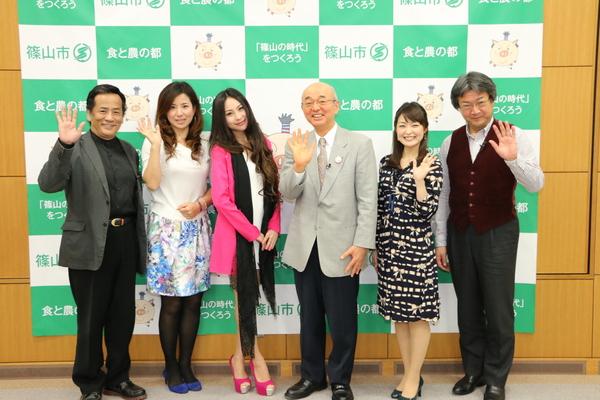 市長を真ん中にふるさと大使の白石 乃梨さん、熊谷 奈美さん、南条 好輝さん、畑 儀文さん、女性司会者が並んで手を振り記念撮影している写真