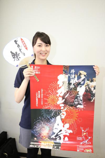 女性の人がデカンショ祭と書かれたポスターとうちわを持っている写真