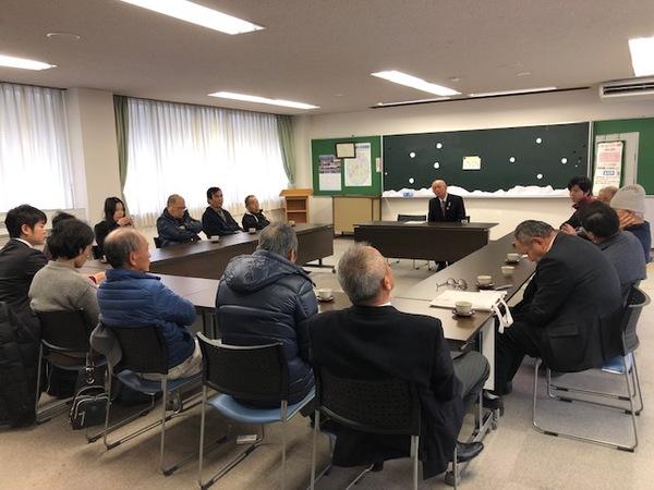 部屋の前方に市長が座り、参加者たちがコの字型に並べられた机に座り話し合いをしている様子の写真