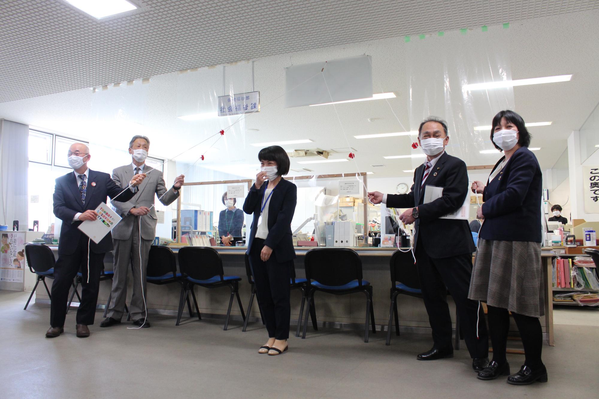 支援センターの除幕式で、ロープを引っ張る参加者の方。