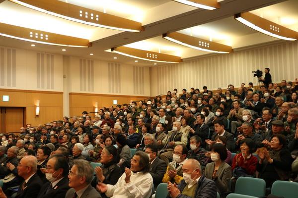 市民で埋め尽くされた会場内の客席の写真