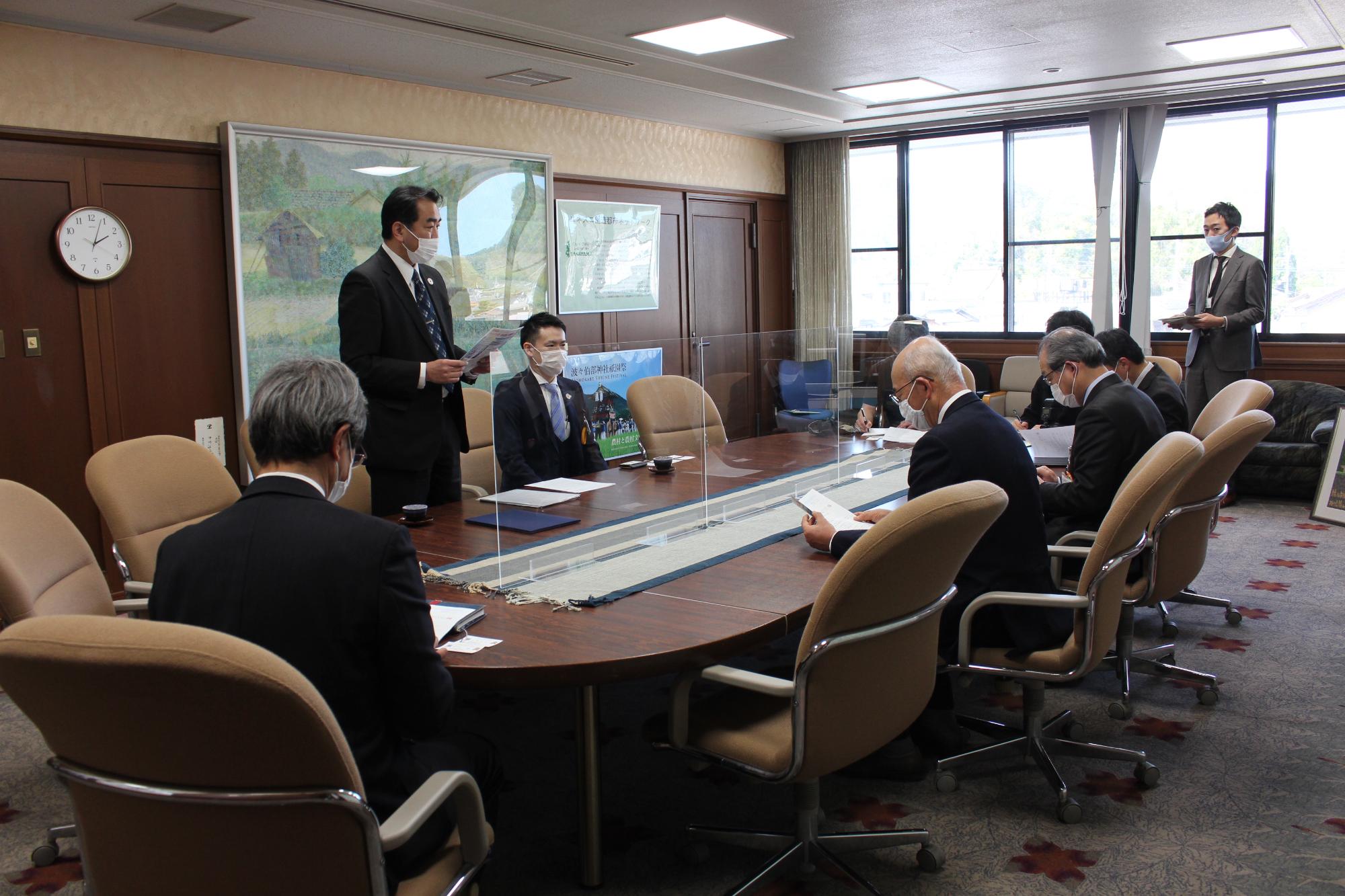 応接室で、男性が立って寄附の趣旨や思いを説明されている。