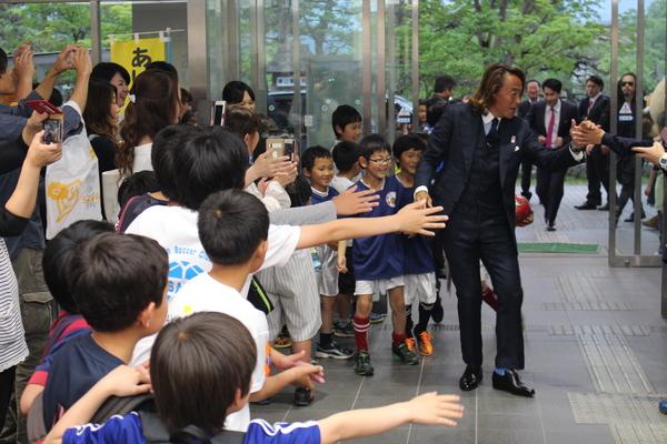 ロビーにてスーツ姿の北澤選手にスポーツフェスタ参加の親子たちが手を振り歓迎している写真