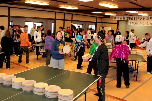 あちこちに卓球台と真ん中に桶が設置されており、集まった方々が写っている室内の写真