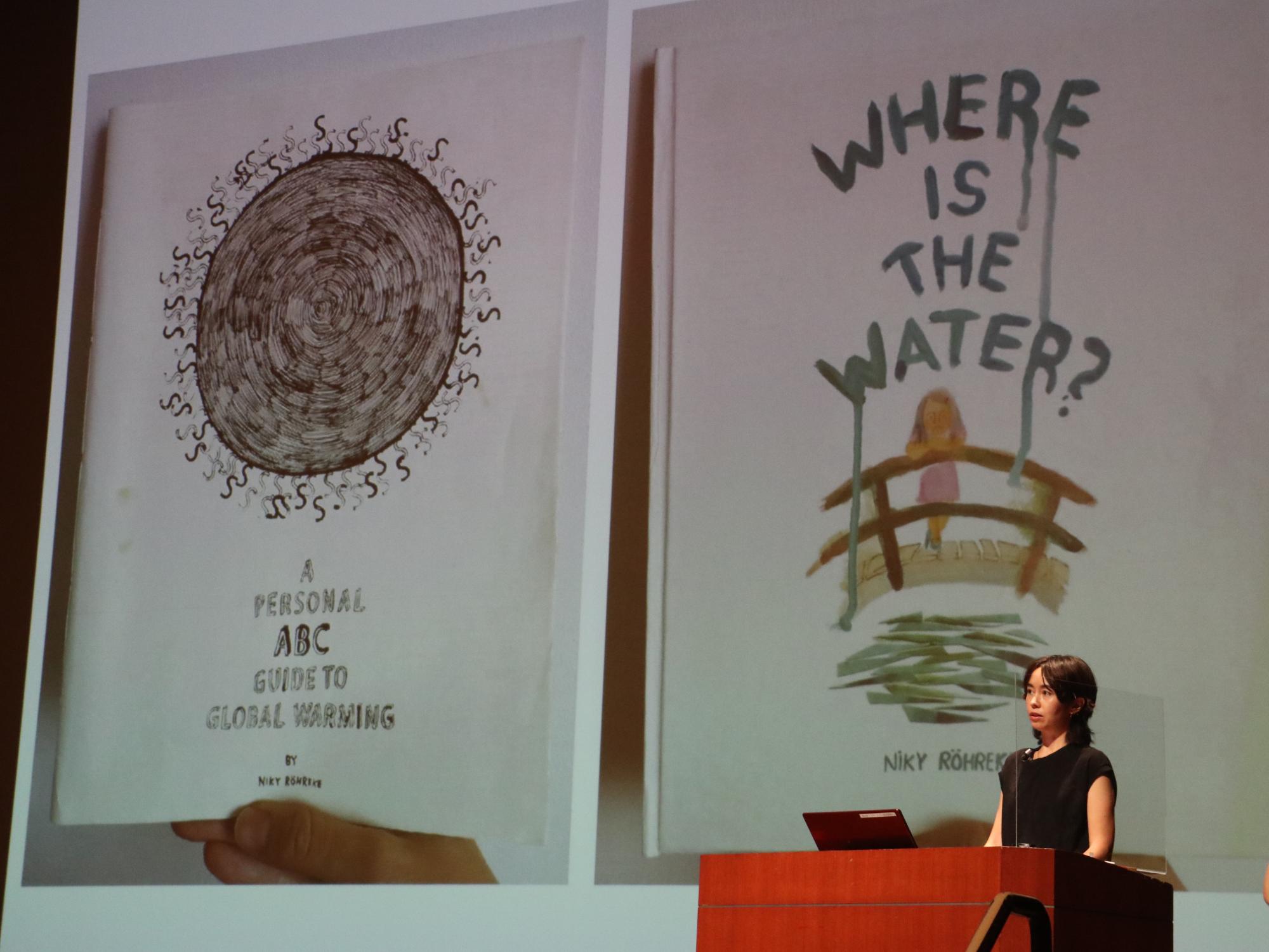 スライドを用いて環境問題をテーマにされたデザインを女性が説明している