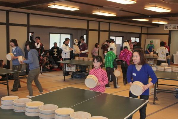 チームごとに分かれて試合が行われており、手前の台ではピンク色に赤の水玉模様の入った洋服を着た女の子と青色の洋服を着た女性が桶を持ち構えている写真