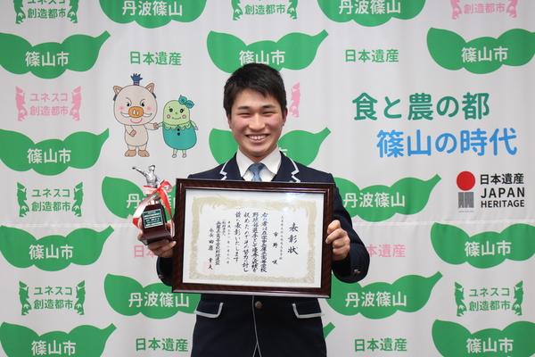 篠山鳳鳴高校軟式野球部3年の市野 咲（いちの しょう）君が賞状とトロフィーを持って笑顔で記念写真