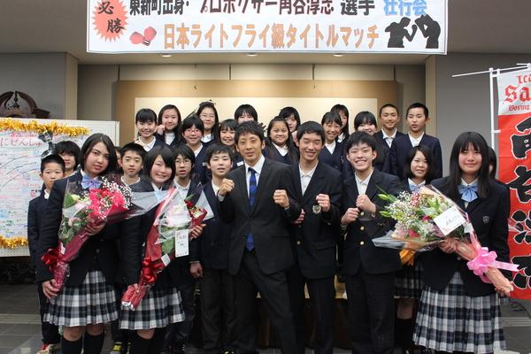 角谷選手はガッツポーズを決めて、両サイドに花束を持った女子生徒と学生で記念写真