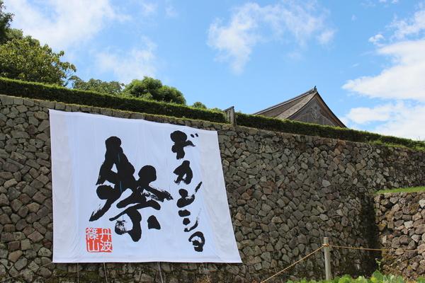 石壁に大きく飾られるデカンショ祭の旗の写真