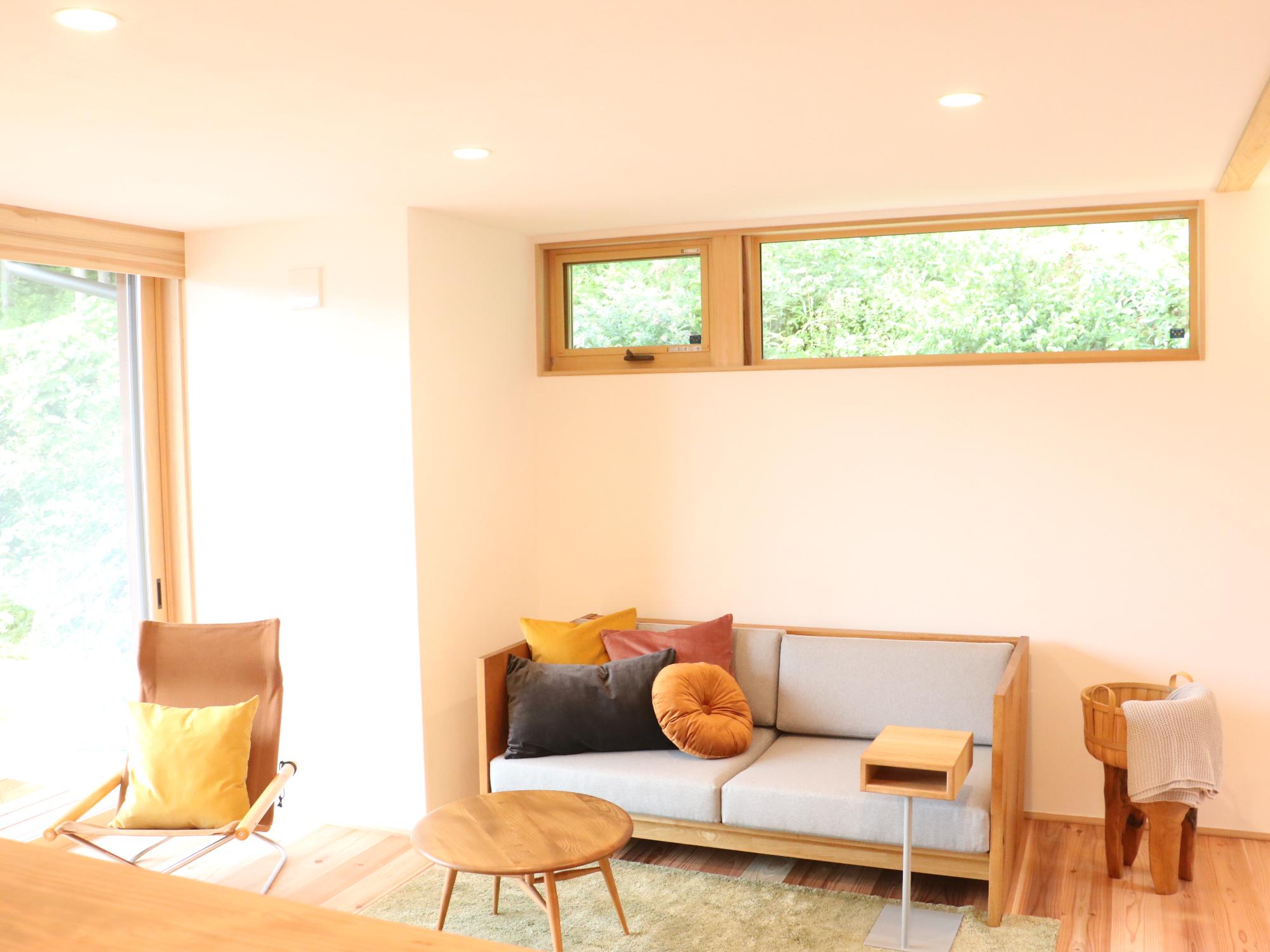丹波篠山の家モデルハウスの内装。ラグの上にミニテーブル。ソファやいすが並んでいる。