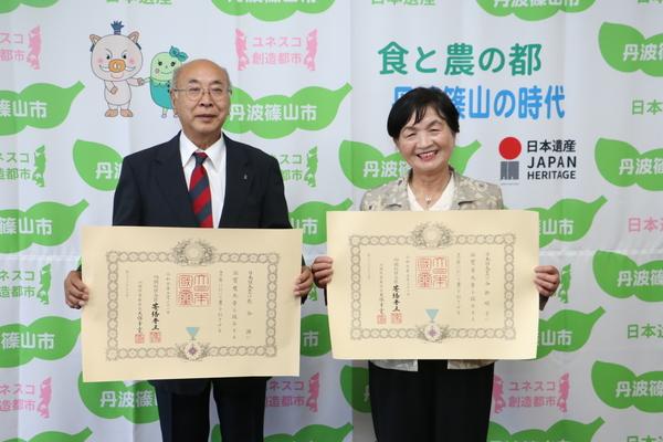 春の叙勲を受賞された熊谷さんと谷掛さんが表彰状を両手に持って撮った笑顔の写真