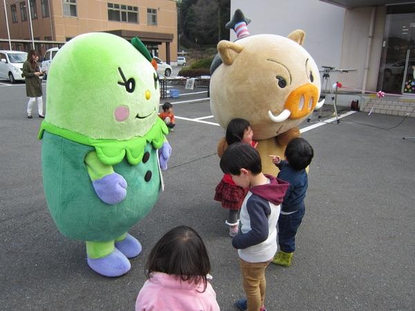 キャラクターのまるいのとまめりんの近くに集まる子供たちの写真