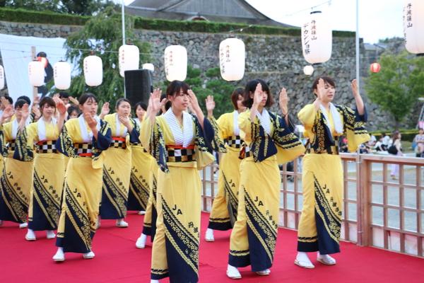 黄色いお揃いの浴衣をきて踊る、女性たちの写真