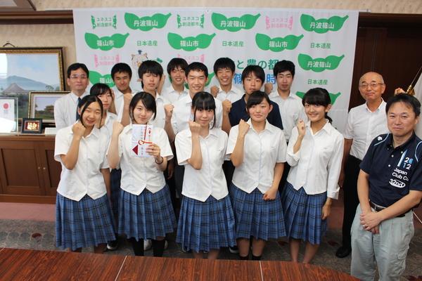 谷田さんが目録を手に持ち部員メンバーと一緒にガッポーズしている記念撮影写真