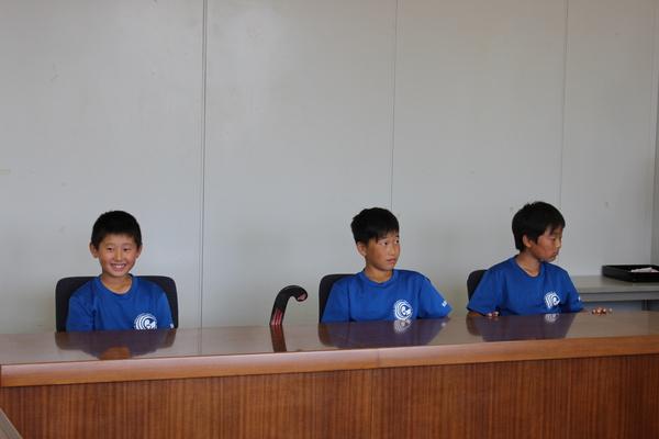 ブルーのTシャツを着た生徒3人が椅子に座っている写真